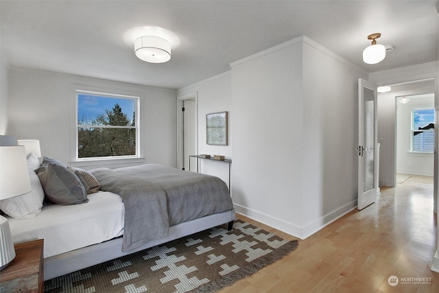 bedroom featuring ornamental molding and light wood-type flooring