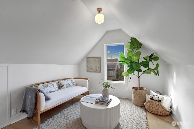 living area with hardwood / wood-style floors and vaulted ceiling