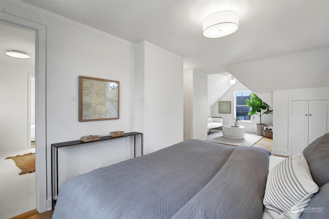 bedroom featuring lofted ceiling and ornamental molding