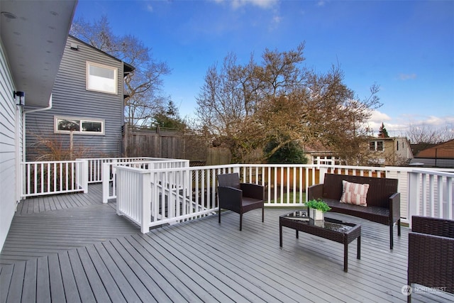 wooden terrace with an outdoor living space