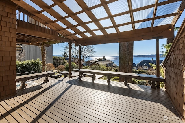 wooden terrace featuring a water view and a pergola