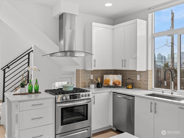 kitchen featuring sink, white cabinets, stainless steel appliances, range hood, and backsplash