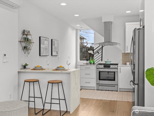 kitchen with appliances with stainless steel finishes, white cabinets, island exhaust hood, kitchen peninsula, and a wall unit AC