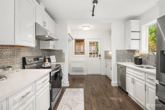 kitchen featuring stainless steel appliances, light countertops, a sink, and under cabinet range hood