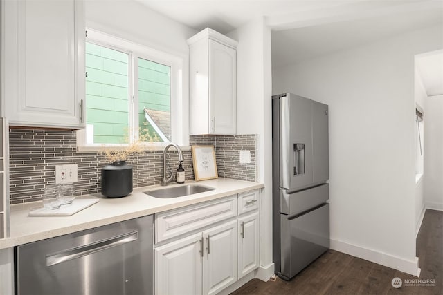 kitchen with tasteful backsplash, white cabinets, appliances with stainless steel finishes, light countertops, and a sink