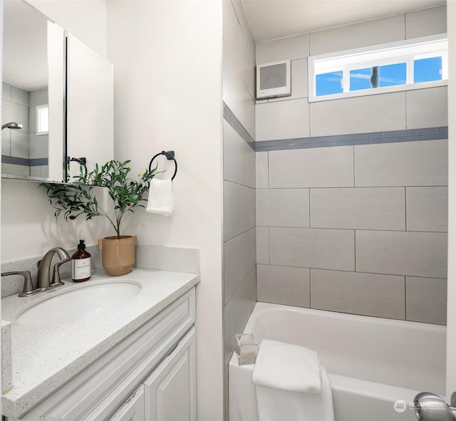 bathroom with a wealth of natural light, a wall mounted air conditioner, bathing tub / shower combination, and vanity