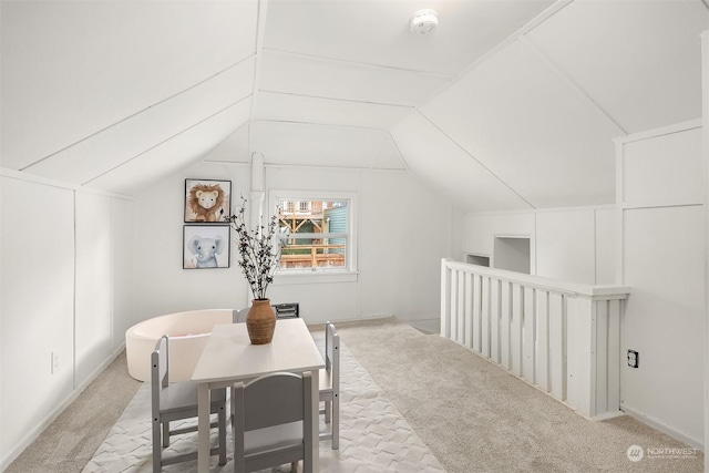 dining room with lofted ceiling and light carpet