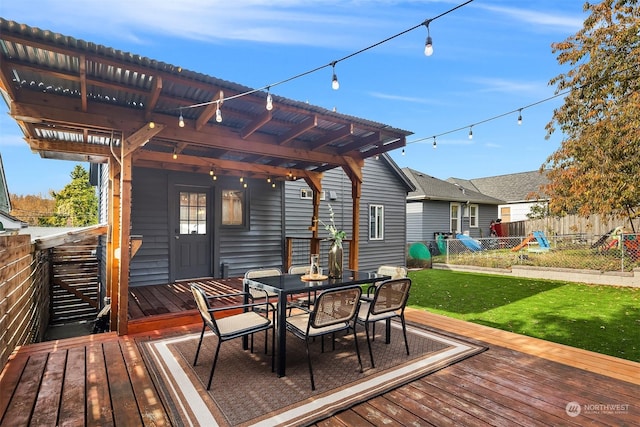 deck featuring outdoor dining area, fence, a lawn, and a pergola