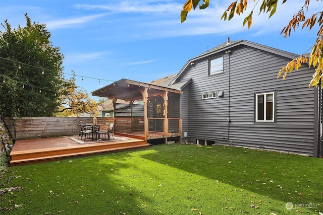 rear view of property featuring a yard and a wooden deck