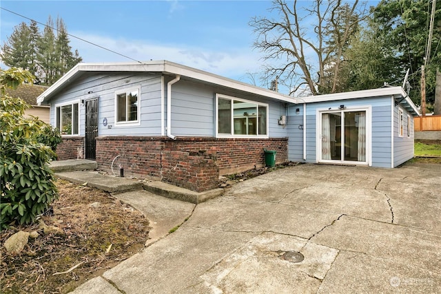 rear view of property featuring a patio area and brick siding