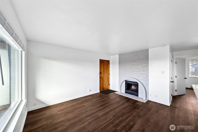 1020 S 230th St Unit 307B, Seattle, WA 98198 - unfurnished living room featuring a fireplace, dark wood finished floors, plenty of natural light, and baseboards