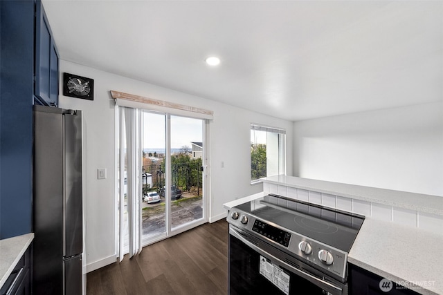 1020 S 230th St Unit 307B, Seattle, WA 98198 - kitchen featuring appliances with stainless steel finishes, dark wood-style flooring, light stone countertops, recessed lighting, and baseboards