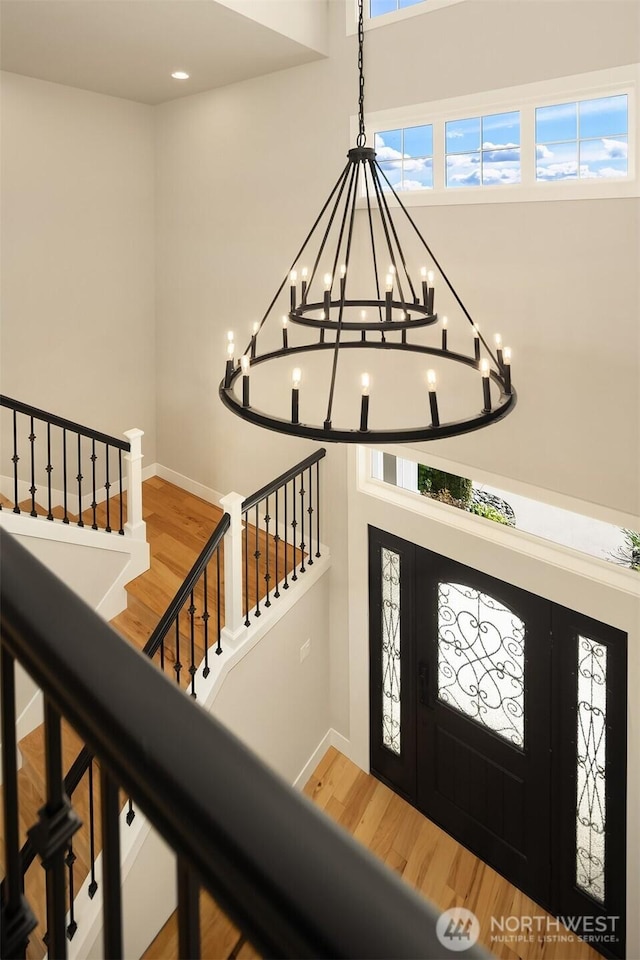 foyer featuring a chandelier, wood finished floors, and baseboards