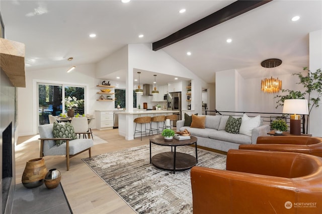 living room with vaulted ceiling with beams, a notable chandelier, and light wood-type flooring