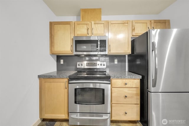 300 110th Ave NE # 611, Bellevue, WA 98004 - kitchen featuring light brown cabinetry, appliances with stainless steel finishes, tasteful backsplash, and baseboards