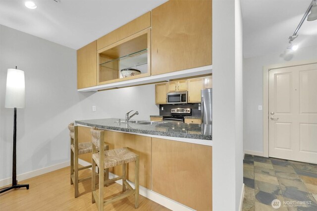 300 110th Ave NE # 611, Bellevue, WA 98004 - kitchen with dark countertops, appliances with stainless steel finishes, baseboards, and a sink