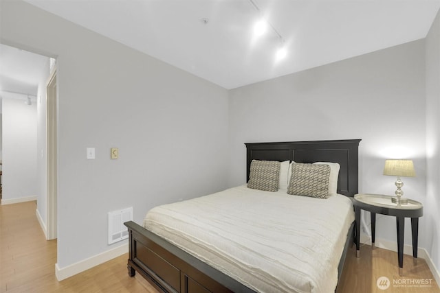 300 110th Ave NE # 611, Bellevue, WA 98004 - bedroom with visible vents, baseboards, light wood-style flooring, and rail lighting