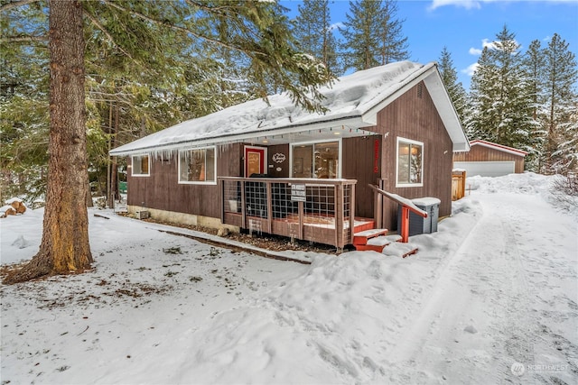 snow covered house with an outbuilding and a garage