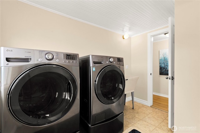 laundry room with independent washer and dryer, ornamental molding, light tile patterned floors, baseboards, and laundry area