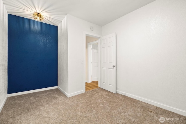 unfurnished bedroom featuring baseboards and carpet