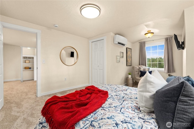 bedroom with baseboards, a wall unit AC, vaulted ceiling, carpet flooring, and a textured ceiling