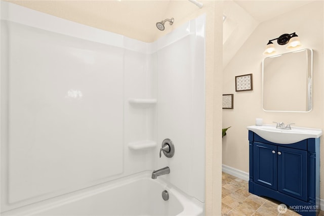 bathroom with vanity, shower / bath combination, and baseboards