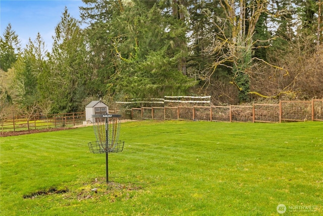 view of yard with a shed, an outdoor structure, and fence