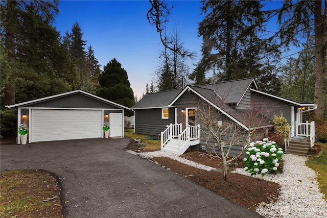 view of front of home with roof with shingles, an outdoor structure, and a detached garage