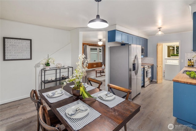 dining area featuring washer / dryer and light wood-style flooring