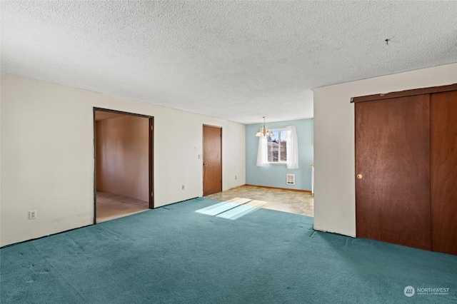 unfurnished bedroom featuring light carpet, a notable chandelier, and a textured ceiling