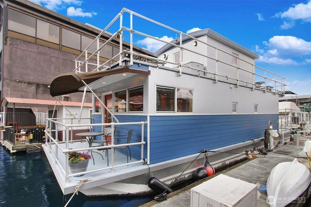 view of property exterior featuring a water view and a dock