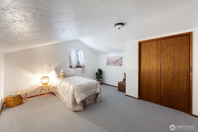 bedroom with a closet, lofted ceiling, carpet floors, and a textured ceiling