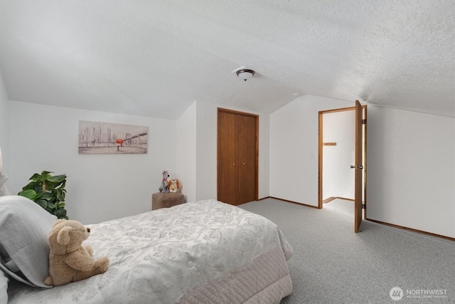 carpeted bedroom with lofted ceiling, a closet, and a textured ceiling