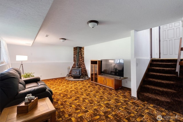 living room with a wood stove and a textured ceiling