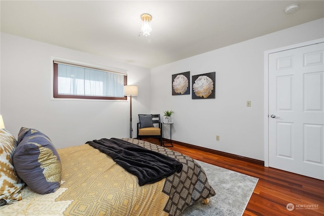 bedroom with dark hardwood / wood-style flooring