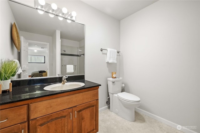 bathroom with vanity, toilet, and a shower with shower door