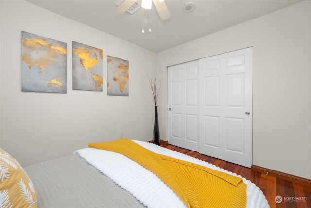 bedroom with ceiling fan, wood-type flooring, and a closet