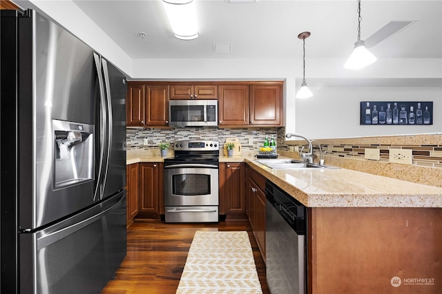 kitchen with appliances with stainless steel finishes, decorative light fixtures, sink, decorative backsplash, and dark wood-type flooring