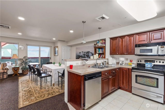 kitchen featuring sink, hanging light fixtures, light tile patterned floors, appliances with stainless steel finishes, and kitchen peninsula