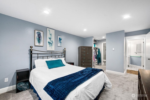 carpeted bedroom featuring ensuite bathroom, a spacious closet, and a closet