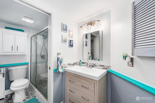 bathroom with an enclosed shower, vanity, and toilet