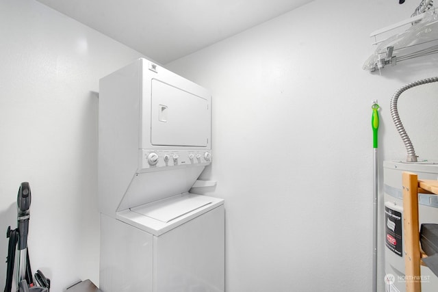 clothes washing area with water heater and stacked washer and clothes dryer