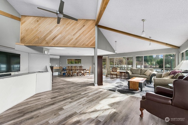 living room featuring hardwood / wood-style flooring, ceiling fan, a textured ceiling, and beamed ceiling