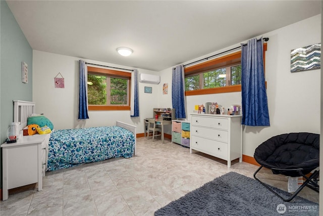 bedroom with multiple windows, baseboards, and a wall mounted air conditioner