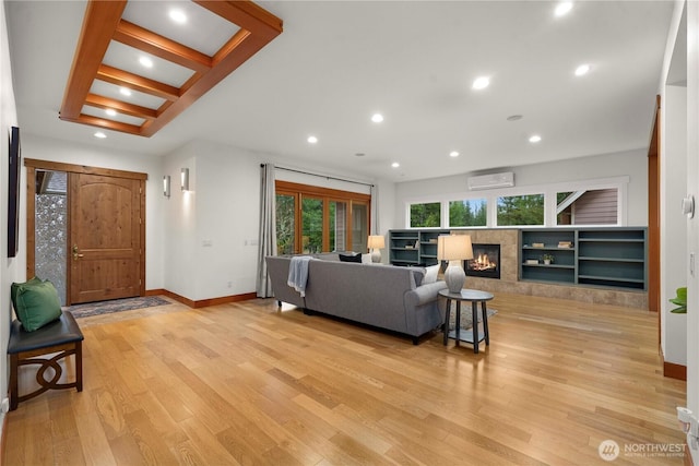 living room featuring a wall unit AC, light wood-style flooring, recessed lighting, a fireplace, and baseboards