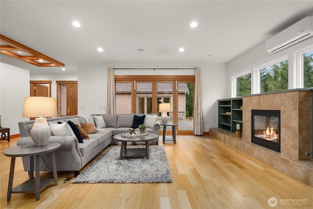 living area featuring baseboards, a tile fireplace, a wall mounted air conditioner, light wood-type flooring, and recessed lighting