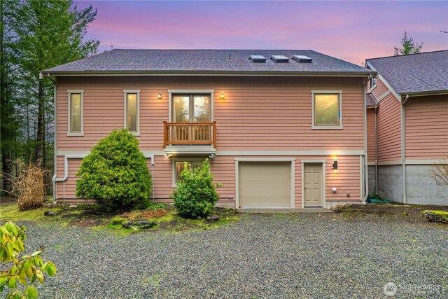 rear view of house featuring driveway and an attached garage