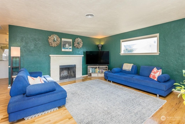 living room with wood-type flooring and a fireplace