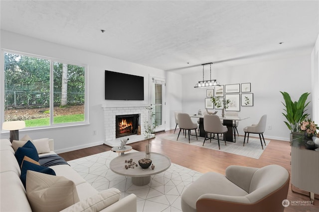 living room featuring a fireplace, wood-type flooring, and a textured ceiling