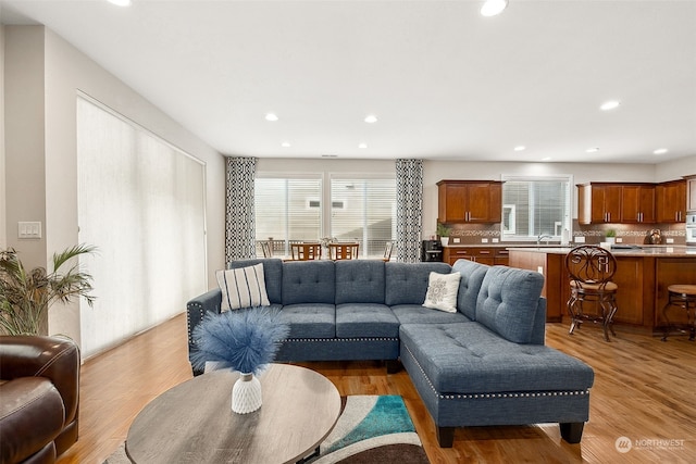 living room with sink, plenty of natural light, and light hardwood / wood-style floors